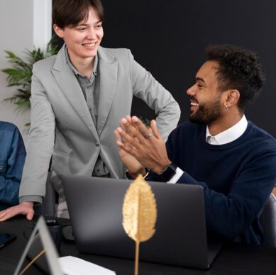 Two colleagues smiling and collaborating in a modern office