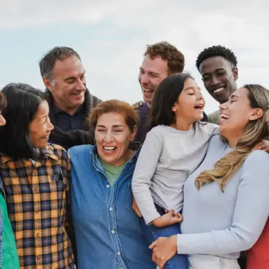 A multigenerational group of people embracing each other in a cheerful moment