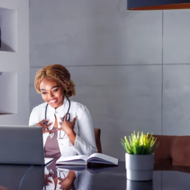 Doctor and patient in an online video call, with the doctor visible on the laptop screen
