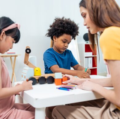 Young woman interacting with two children during an activity