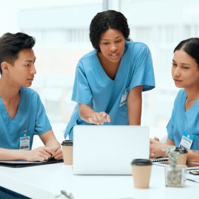 Team of doctors reviewing medical information together on a laptop