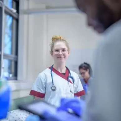 Healthcare professionals collaborating in front of a laptop during a virtual meeting