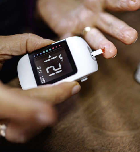 Checking blood sugar levels with a glucose meter while at home.