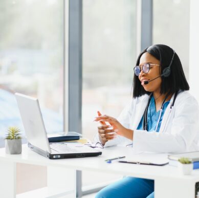 Young African-American doctor working on laptop in clinic